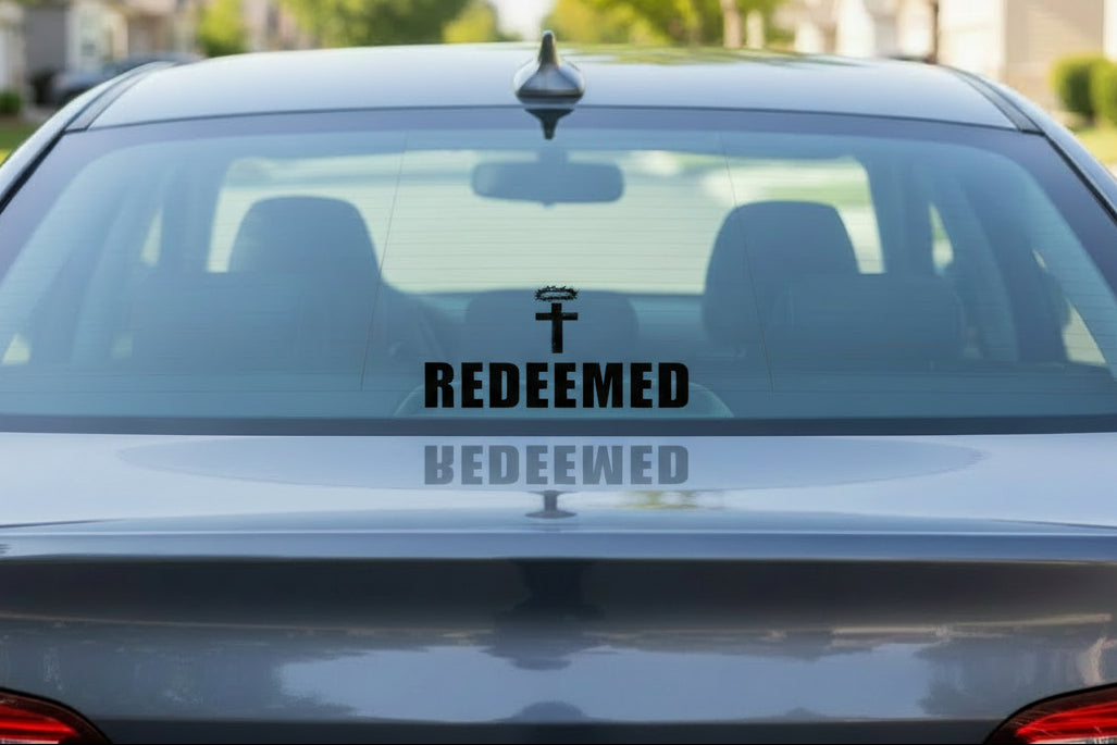 Cross with wreath above 'REDEEMED' on a white background